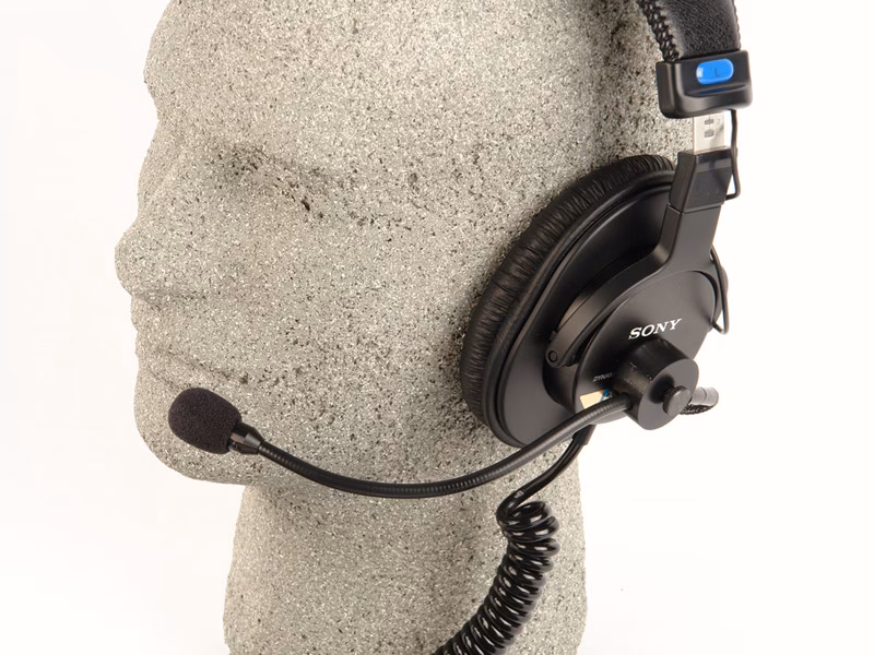 Why do shotgun boom operators use headphones?