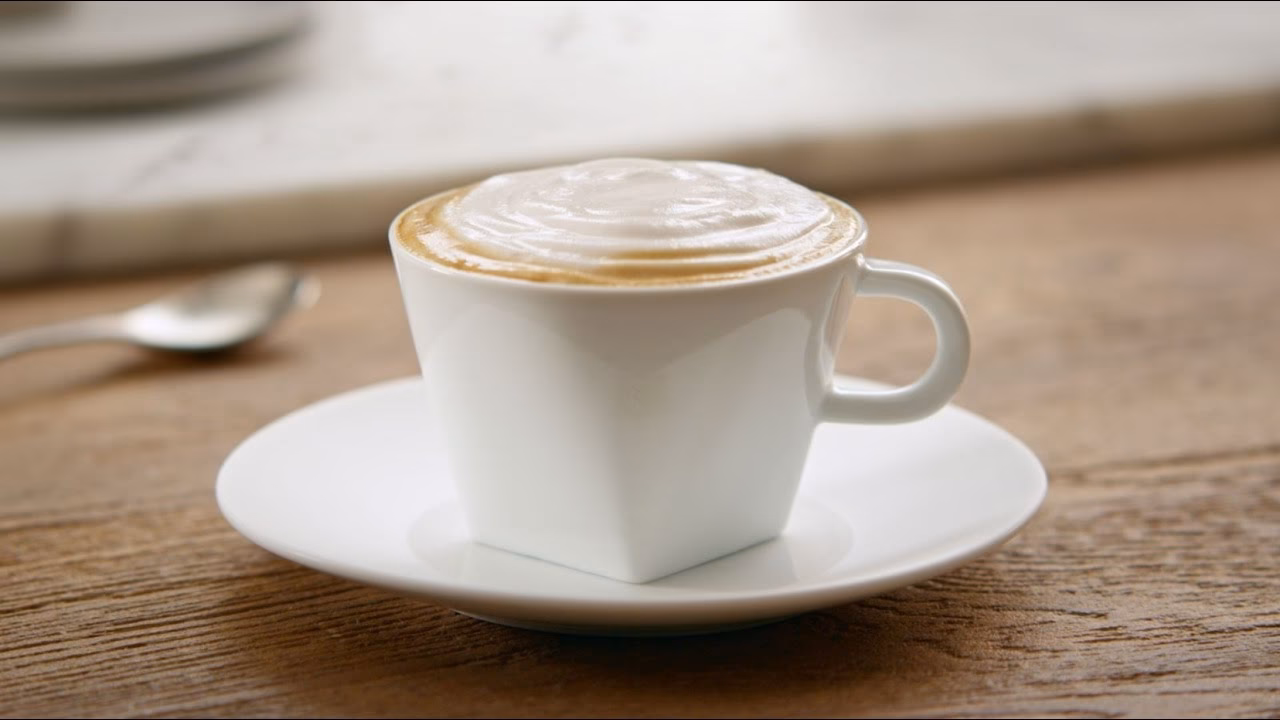 How do you make a creamy cappuccino with a Nespresso machine?