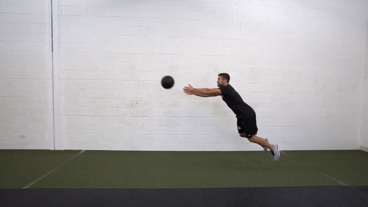 What is a medicine ball sit-up toss?