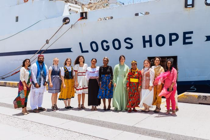 Why do OM Ships travel around the world?